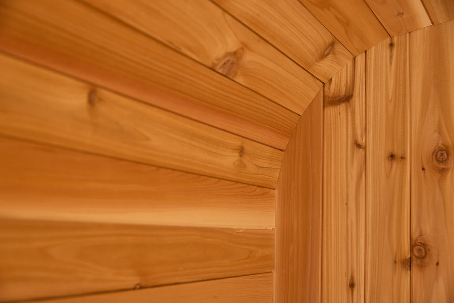 Close-up of smooth, light brown cedar planks on a curved wall, highlighting natural grain—ideal for the Almost Heaven BlackWater 4 Person Cube Sauna or any luxury outdoor sauna from Almost Heaven.