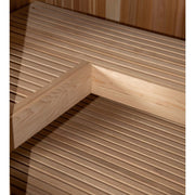 Close-up view of the light-colored, evenly spaced wooden benches and floor inside the Almost Heaven Denali 6 Person Indoor Sauna by Almost Heaven.
