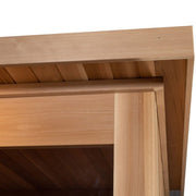 Close-up view of the Almost Heaven Denali 6 Person Indoor Sauna’s light wood structure, showing a corner joint with overlapping beams and slatted ceiling panels by Almost Heaven.