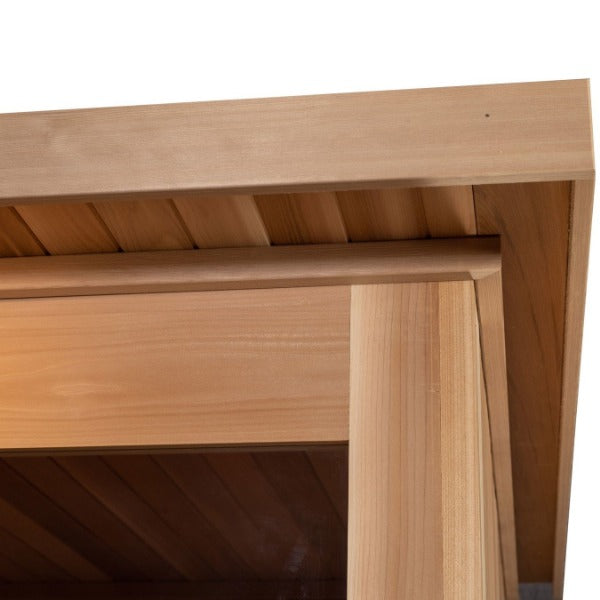 Close-up view of the Almost Heaven Denali 6 Person Indoor Sauna’s light wood structure, showing a corner joint with overlapping beams and slatted ceiling panels by Almost Heaven.