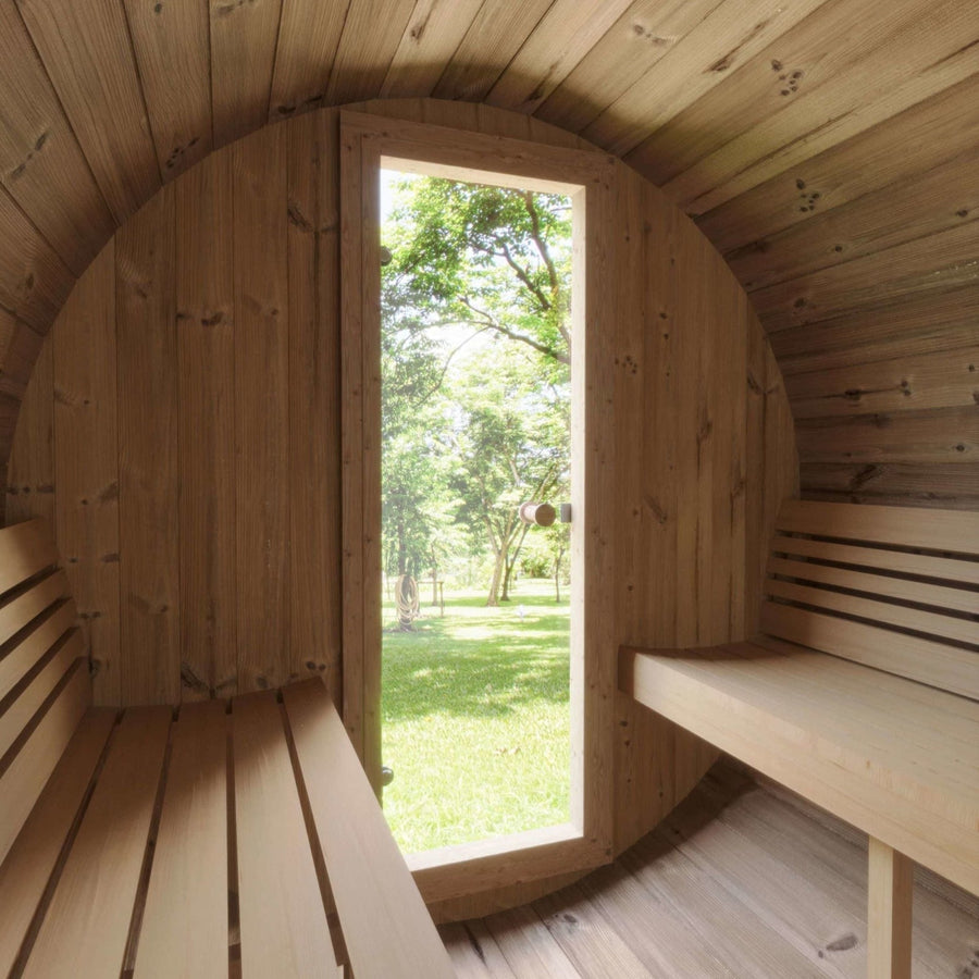 The SaunaLife Model E6W 3 Person Sauna Barrel-Window features Thermo-Spruce benches on both sides and a tall window at the end, offering serene views of a sunlit green garden.