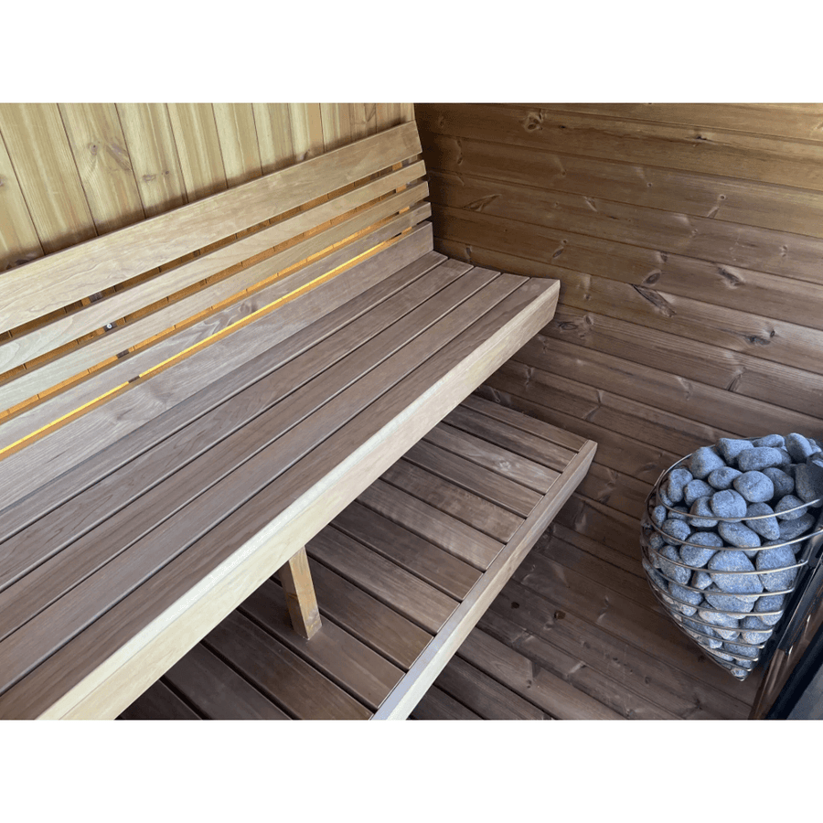 The SaunaLife Model EE6G 4 Person Barrel Sauna features a wooden interior with two-tiered benches and a gray-stone heater, combining light and dark wood for modern elegance.