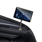 A touchscreen on a car door shows a health interface with a body diagram, connected by cable—similar to the personalized massage technology of the Osaki 4D Orion Duo Mech Massage Chair by Osaki.