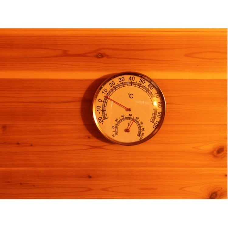 A round thermometer and hygrometer mounted on wood show 60°C and 20% humidity, capturing the inviting atmosphere of a SunRay Denali 4-Person Contemporary Outdoor Sauna—perfect for relaxing in your outdoor SunRay sauna.