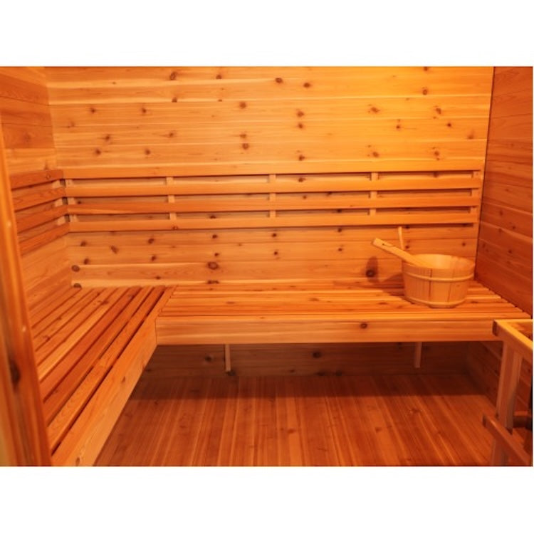The SunRay Denali 4-Person Contemporary Outdoor Sauna features a red cedar interior, benches along the walls, and a wooden bucket with ladle. Warm lighting highlights the natural wood grain for a cozy SunRay sauna experience.