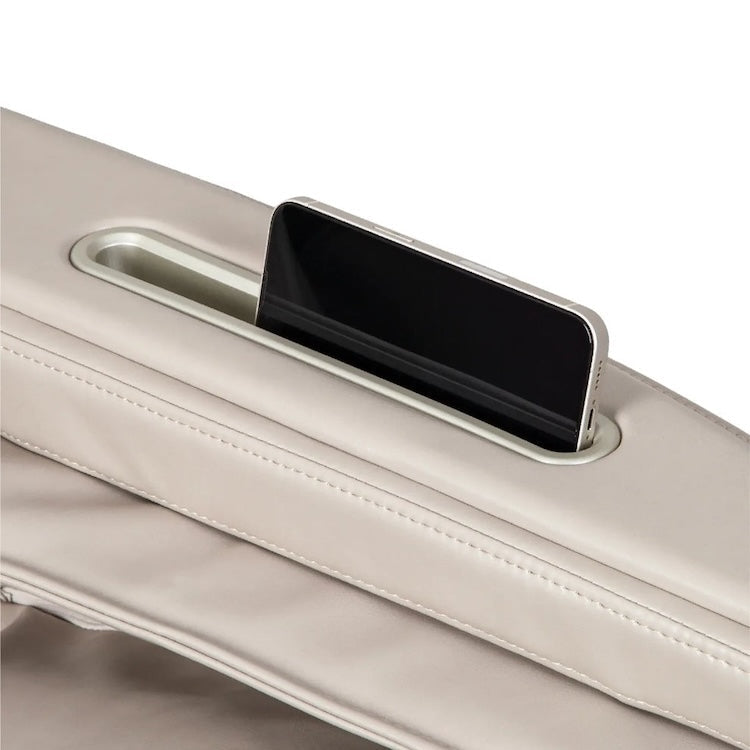 A smartphone is placed vertically in a built-in slot on the beige leather surface of the Titan Grande XL 3D Massage Chair by Titan.