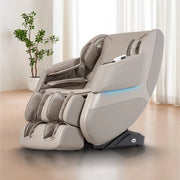 The Titan Grande XL 3D Massage Chair by Titan, featuring a modern beige design with multiple cushions and armrests, is placed in a bright room with a large window and a potted plant in the background.