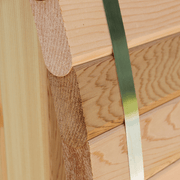 Close-up of finely crafted wooden planks with rounded edges, secured by a metal strap—premium quality for the Almost Heaven Grandview 4-6 Person Canopy Barrel Sauna. The wood grain highlights craftsmanship from the trusted Almost Heaven brand.