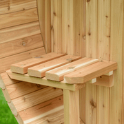 Close-up of a wooden corner shelf crafted from light, unfinished planks, mounted on a wooden wall outdoors—ideal for organizing essentials in your Almost Heaven Grandview 4-6 Person Canopy Barrel Sauna, with green grass outside.