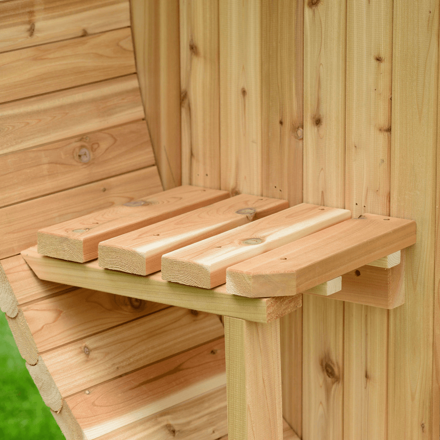 Close-up of a wooden corner shelf crafted from light, unfinished planks, mounted on a wooden wall outdoors—ideal for organizing essentials in your Almost Heaven Grandview 4-6 Person Canopy Barrel Sauna, with green grass outside.