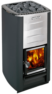 A metal sauna stove with black sides, a stainless steel front, and a glass fire-view door sits inside the Almost Heaven Grandview 4-6 Person Canopy Barrel Sauna, topped with dark stones. “HARVIA” is displayed above the door.