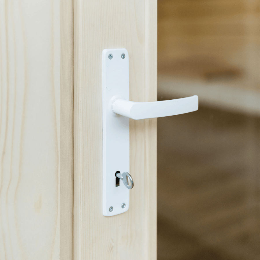 Close-up of a white handle and lock on a light wooden door with a key, set against the serene entryway of an Almost Heaven Timberline 6 Person Cabin Sauna.