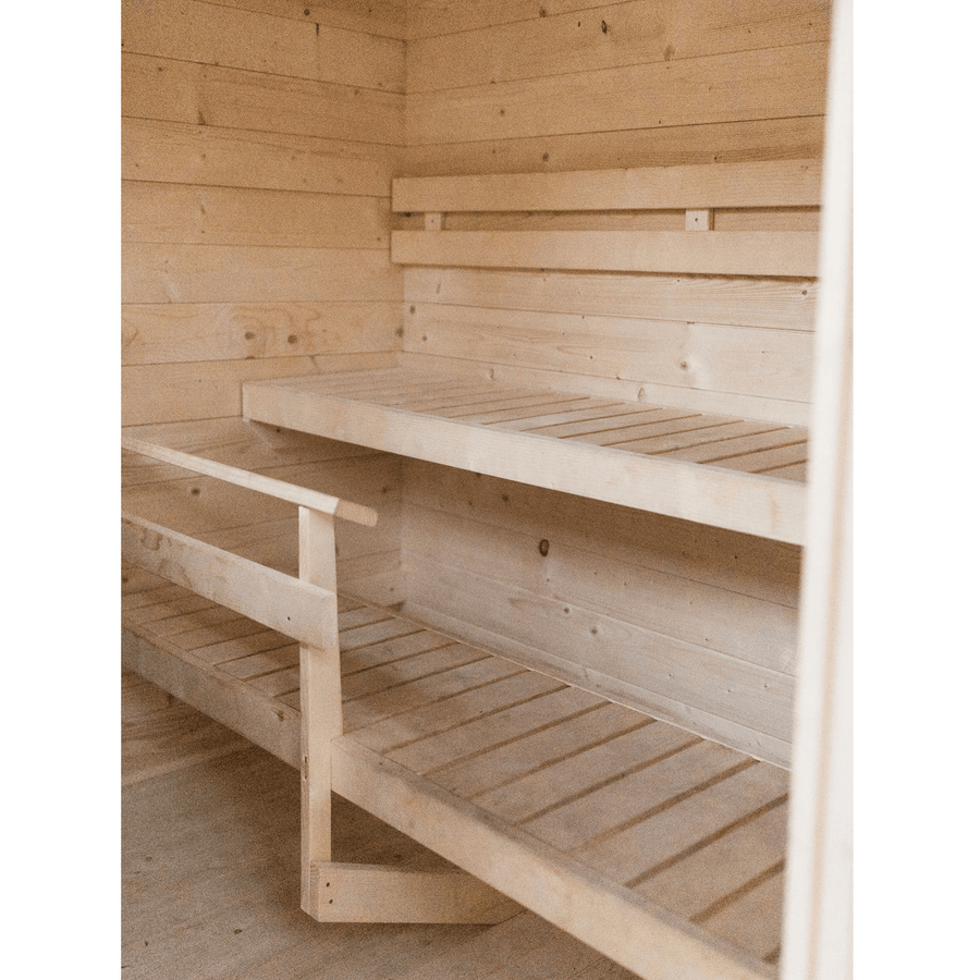 The Almost Heaven Timberline 6 Person Cabin Sauna features two-tier bench seating and light wood paneling, creating a spacious, well-lit, and serene retreat for your outdoor space.