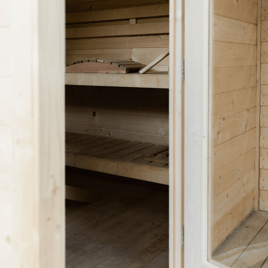 The Almost Heaven Timberline 6 Person Cabin Sauna features a clean, minimal interior with light wood walls and benches that showcase natural wood grain, creating a relaxing retreat for up to six people.