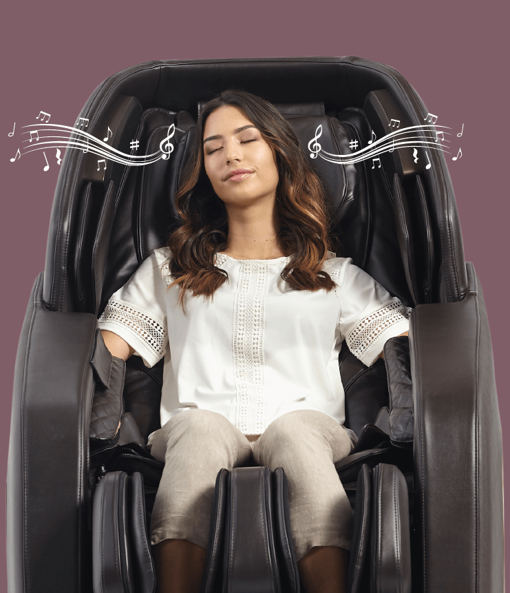 A woman relaxes in the Daiwa Hubble Massage Chair by Daiwa, eyes closed in comfort as airbag massage soothes her. Musical notes above her imply she's enjoying music while sitting back in this wall-hugger chair, dressed in a white blouse and beige pants.