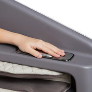A child’s hand presses a rectangular silver button on a quilted gray surface, highlighting the intuitive controls of the Osaki Flagship Duo Massage Chair with advanced AI massage technology.