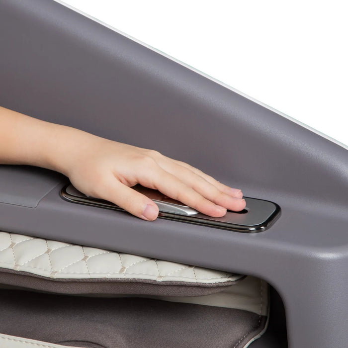 A child’s hand presses a rectangular silver button on a quilted gray surface, highlighting the intuitive controls of the Osaki Flagship Duo Massage Chair with advanced AI massage technology.