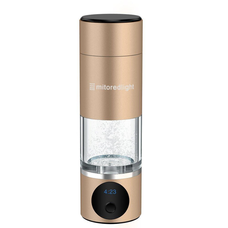 The MitoHYDRO™ Ultra Premium Hydrogen Water Bottle by Mito Red Light features a gold finish, transparent middle, digital display at 4:23, and a black button. "mitoredlight" is printed on the bottle—enjoy antioxidant-rich hydrogen water anywhere.