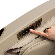 A finger pressing a control button on the Osaki 4D Maestro LE 2.0 Massage Chair in a car.