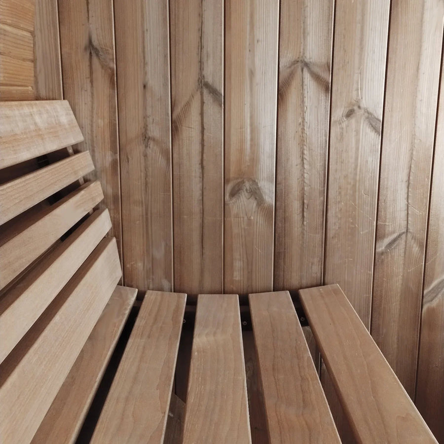 A close-up of the SaunaLife Model E8W 6 Person Sauna Barrel-Window interior shows a slatted bench and paneled wall, all crafted from smooth, light-colored Thermo-Spruce sauna wood by SaunaLife.