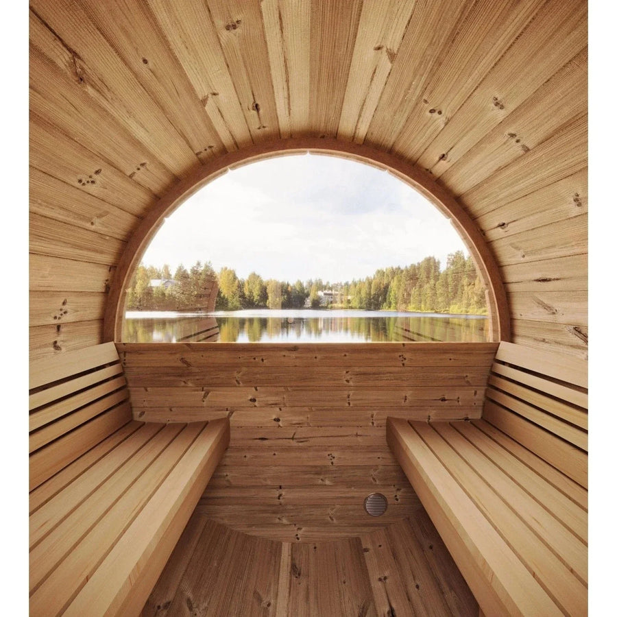The SaunaLife Model E6W 3 Person Sauna Barrel-Window by SaunaLife features Thermo-Spruce construction, dual side benches, and a large round window offering restful views of a lake and trees beneath a partly cloudy sky.