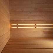 The SaunaLife G6 5-Person Outdoor Cabin Sauna features smooth wooden panels on walls and benches, illuminated by soft, warm lighting behind horizontal slats for a modern luxury interior.