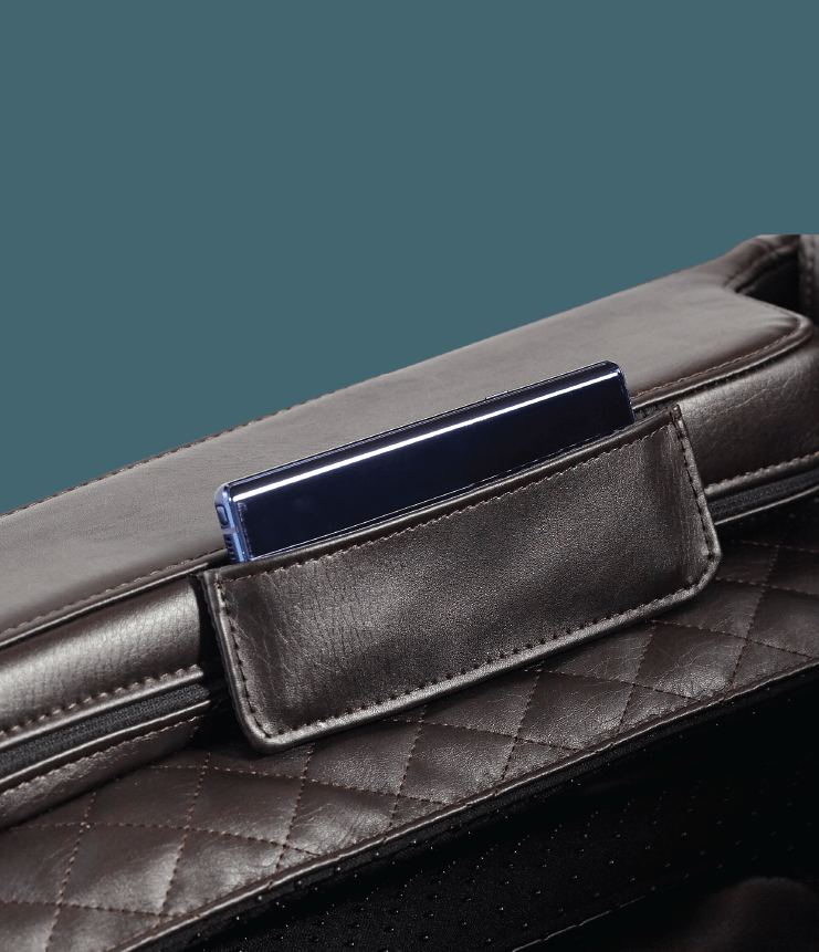 A close-up of a dark quilted leather bag with a slim dark blue smartphone in its pocket, evoking the space-saving efficiency seen in modern designs like the Daiwa Legacy 4 Massage Chair by Daiwa.