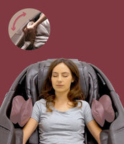 A woman relaxes with closed eyes in a Daiwa Majesty Massage Chair by Daiwa, featuring padded armrests. An inset highlights a hand adjusting the chair’s 3D body scan controls. The background is solid maroon.