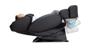 A person relaxes in the Daiwa Supreme Hybrid Massage Chair by Daiwa, featuring a modern black design and an L-shaped massage track, with raised legs for support while enjoying a soothing massage.