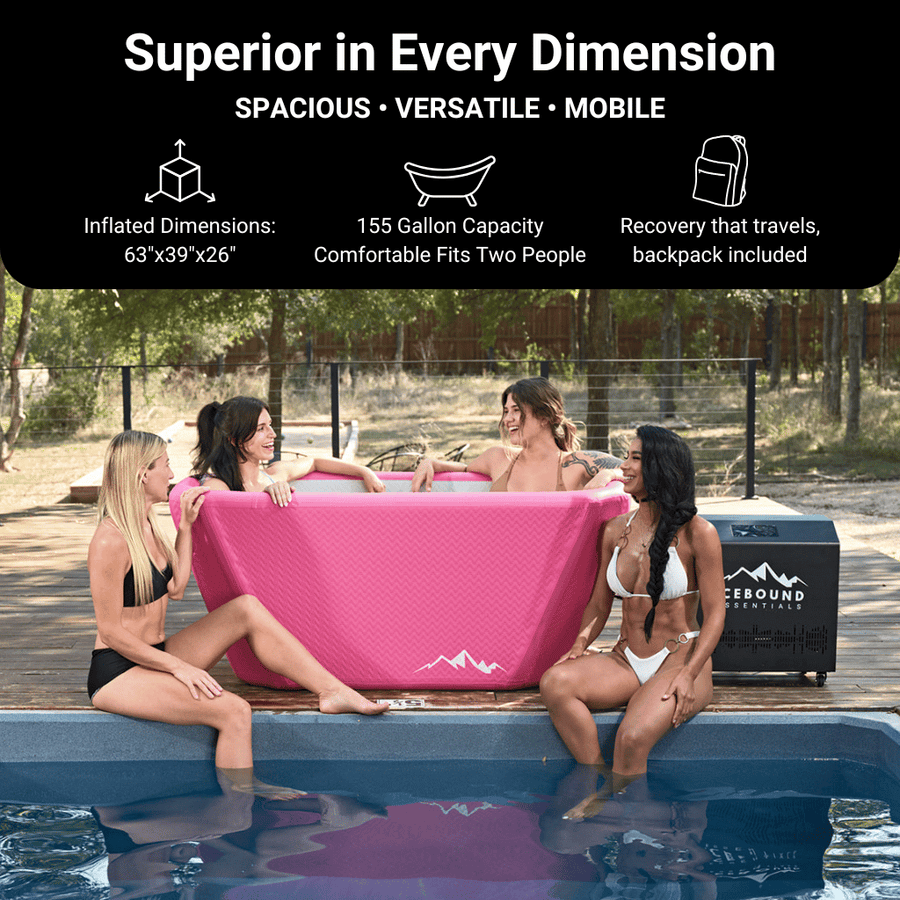 Four women in swimsuits smile and sit in the Pink Endurance Plunge + Chiller by Icebound Essentials beside a pool. Text highlights its spacious, versatile, and portable design, with ample capacity. Trees and a fence are seen behind them.