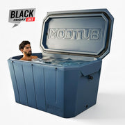 A man relaxes in a large blue Modtub 2.0 Cold Plunge (Tub Only) by Modtub, made in the USA, with its lid open. A Black Friday Sale sign appears in the top left corner on a plain white background.