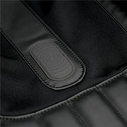 Close-up of the Osaki 4D YogaFlex Massage Chair's black padded surface with stitched seams and an oval, textured central patch featuring concentric circles, highlighting Osaki's signature design.