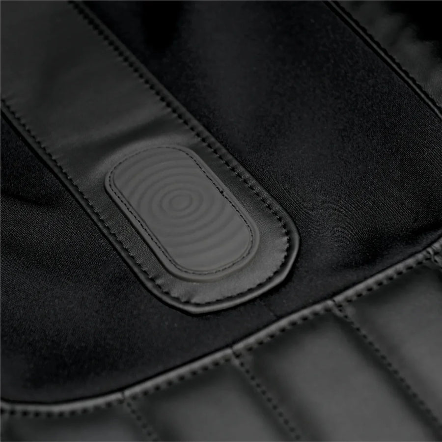 Close-up of the Osaki 4D YogaFlex Massage Chair's black padded surface with stitched seams and an oval, textured central patch featuring concentric circles, highlighting Osaki's signature design.