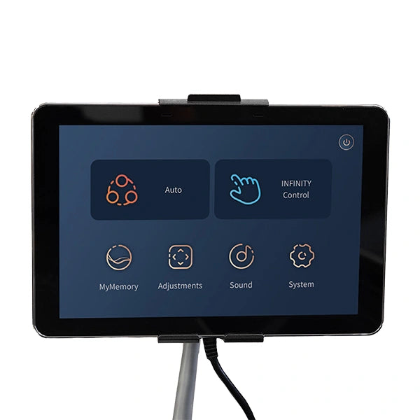 A touchscreen tablet on a stand shows the Infinity Imperial Syner-D Massage Chair control panel by Infinity, with Flex-Track and Syner-D Technology options: Auto, Infinity Control, MyMemory, Adjustments, Sound, System, and a power button icon at top right.