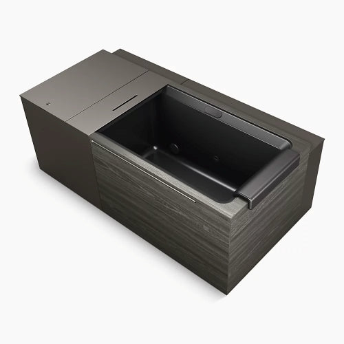 The Kohler x Remedy Place Ice Bath by Kohler is a modern, rectangular black tub with a built-in headrest and dark wood-look panels—perfect for hydrotherapy or cold plunges—shown against a plain white background.