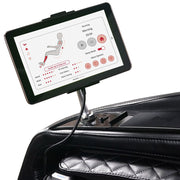 A tablet showing position, speed, intensity, and heating settings is mounted on an adjustable holder attached to the black quilted armrest of the Kyota Kizuna M688 Massage Chair by Kyota.