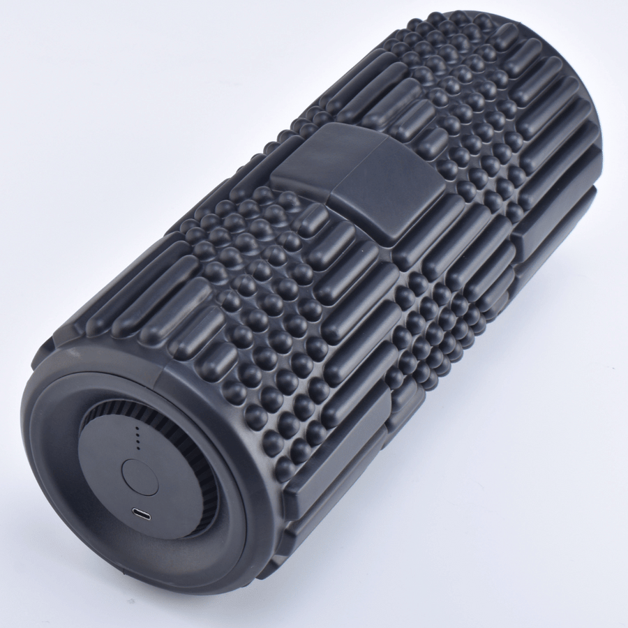 The VibePro Flow by Icebound Essentials is a black textured vibrating foam roller with grid and knob patterns, circular end featuring charging port and indicator lights, designed for deep massage and effective muscle recovery.