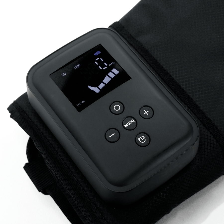 A close-up of the HEALiX Flow by HEALiX Infrared, a black electronic device with a digital display and control buttons, shown on textured black fabric. The screen displays numbers, icons, and settings for time and mode.