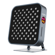 The RLT Home Total Spectrum MINI Red Light Therapy Panel by RLT Home features a modern rectangular design with multiple small LEDs, a sleek gray frame, and a digital control panel with pink, orange, and yellow buttons on the right. It’s stand-mounted for easy home wellness use.