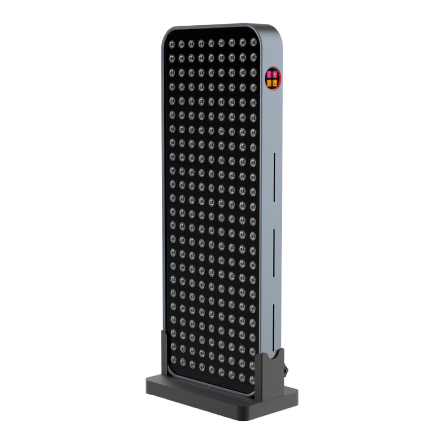 The RLT Home Total Spectrum COMPACT (7 Wave 216 LEDs) is a tall, rectangular red light therapy device with a grid of circular lights on the front and a small logo on the upper side edge, designed to aid pain recovery and support mitochondrial function.