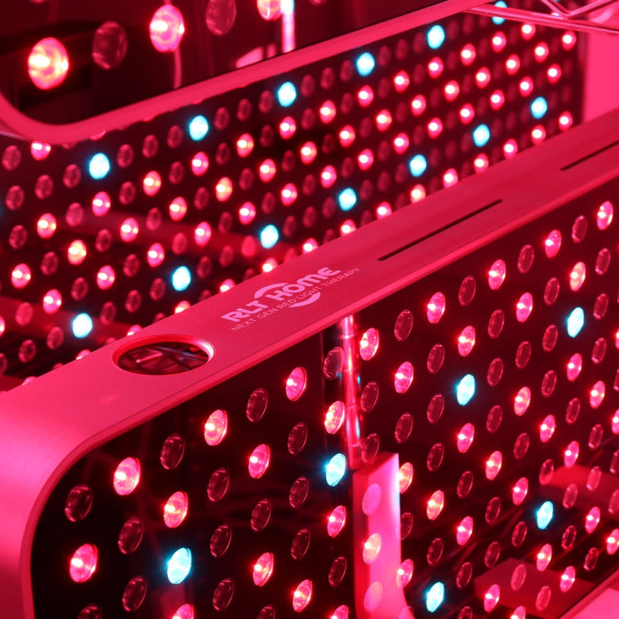 Close-up of the RLT Home Total Spectrum MAX Red Light Therapy Panel by RLT Home, featuring numerous red and a few blue LEDs illuminated and reflected in a mirror—ideal for mitochondrial stimulation and holistic wellness.