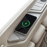 A smartphone is wirelessly charging on a built-in pad in the armrest of the light-colored Osaki Ai series Apex Duo 5D+4D massage chair. The phone screen displays a green charging icon and shows it is 75% charged.