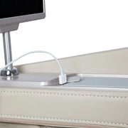 A close-up of an Osaki Ai series Apex Duo 5D+4D massage chair’s beige leather headboard shows a charging cable plugged into its USB port, with part of a device screen visible above the port.