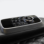 A close-up of Daiwa’s Pegasus Hybrid Massage Chair shows a sleek black control panel with a circular dial and buttons, embedded in the armrest for full-body relaxation.