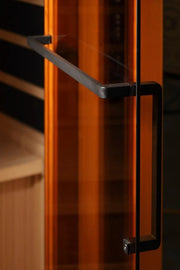Close-up of the Golden Designs Reserve Edition GDI-8040-03 Full Spectrum sauna's tempered glass door with a black handle.