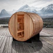 Golden Designs Arosa 4 Person Barrel Traditional Sauna - Pacific Cedar on a wooden deck with mountains in the background, door open revealing interior.