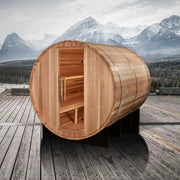 Golden Designs Klosters 6 Person Barrel Traditional Sauna - Pacific Cedar, shown on a wooden deck with mountains in the background, door open displaying interior space.