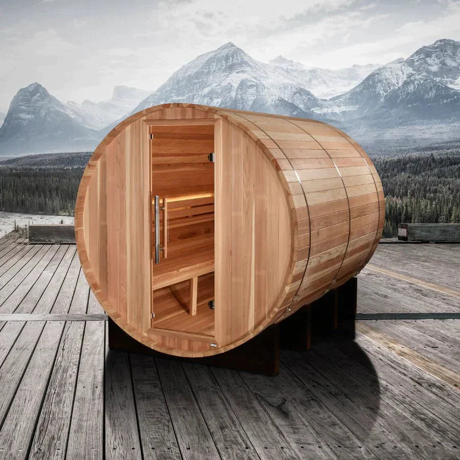 Golden Designs Klosters 6 Person Barrel Traditional Sauna - Pacific Cedar, shown on a wooden deck with mountains in the background, door open displaying interior space.
