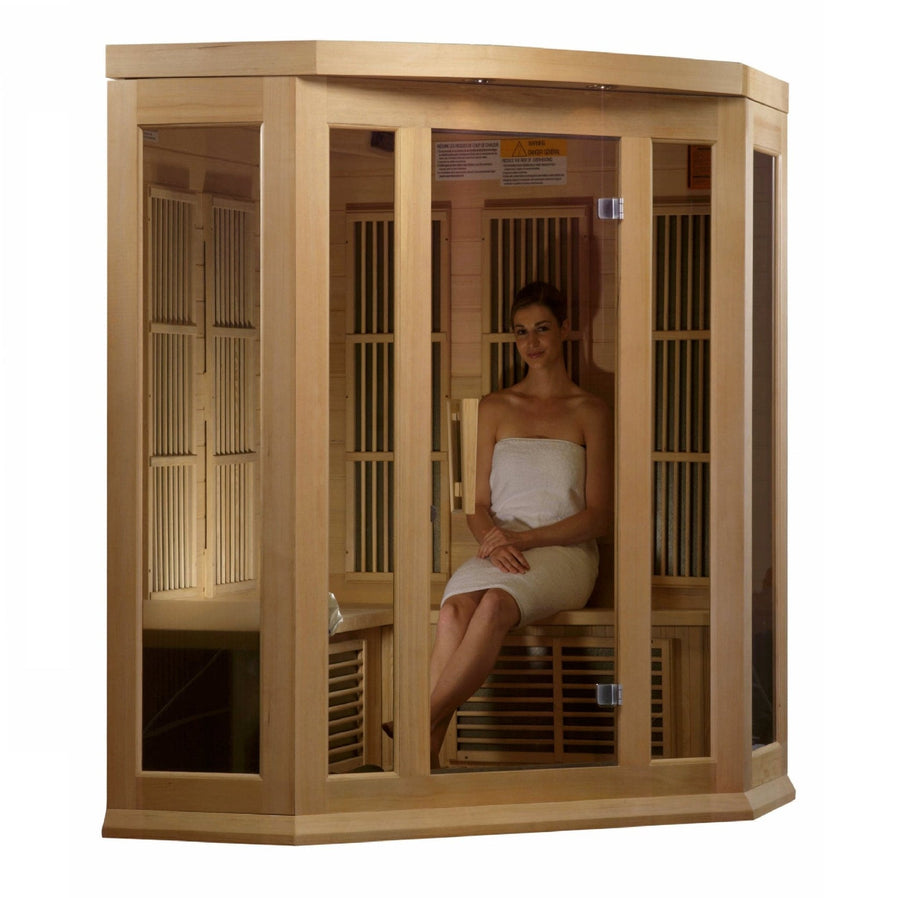 A woman in a white towel sitting in a Maxxus 3 Person Low EMF FAR Infrared Sauna Canadian Hemlock.