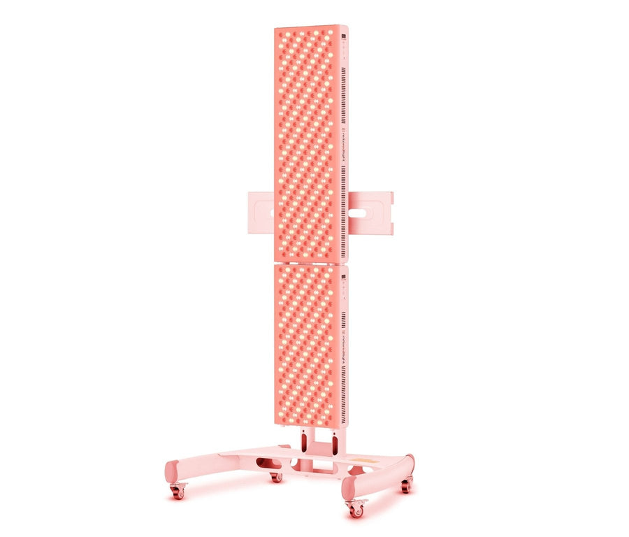 The Mito Red Light MitoPRO+ | Red Light Therapy Panel Series v2 is a tall, rectangular panel with quad wavelength LEDs, featuring multiple small bulbs and mounted on a pink wheeled stand for easy mobility.